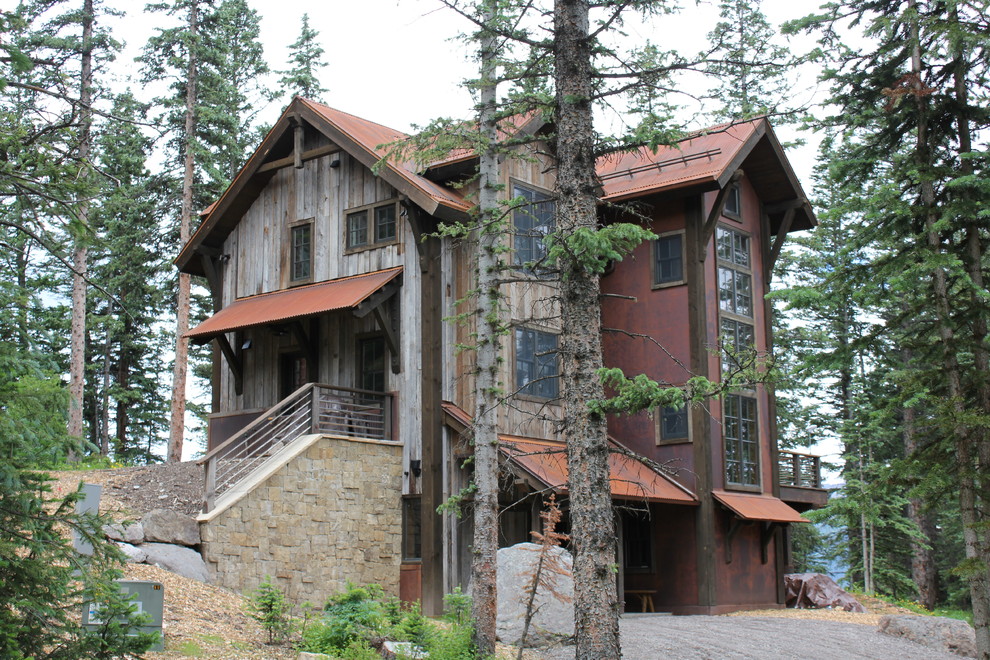 Foto på ett rustikt brunt trähus i flera nivåer, med tak i metall