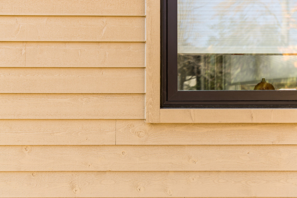 Foto della facciata di una casa beige classica a un piano di medie dimensioni con rivestimento in legno e tetto a capanna