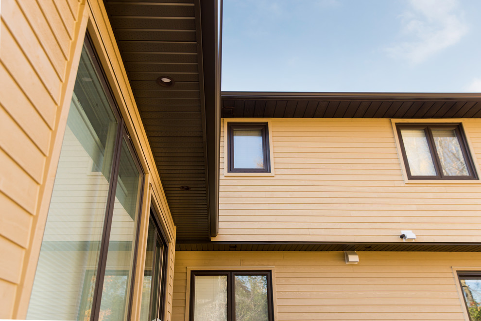 Idées déco pour une façade de maison beige classique en bois de taille moyenne et de plain-pied avec un toit à deux pans.