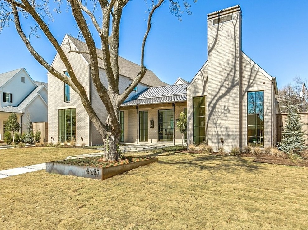 Large transitional beige two-story brick gable roof photo in Dallas