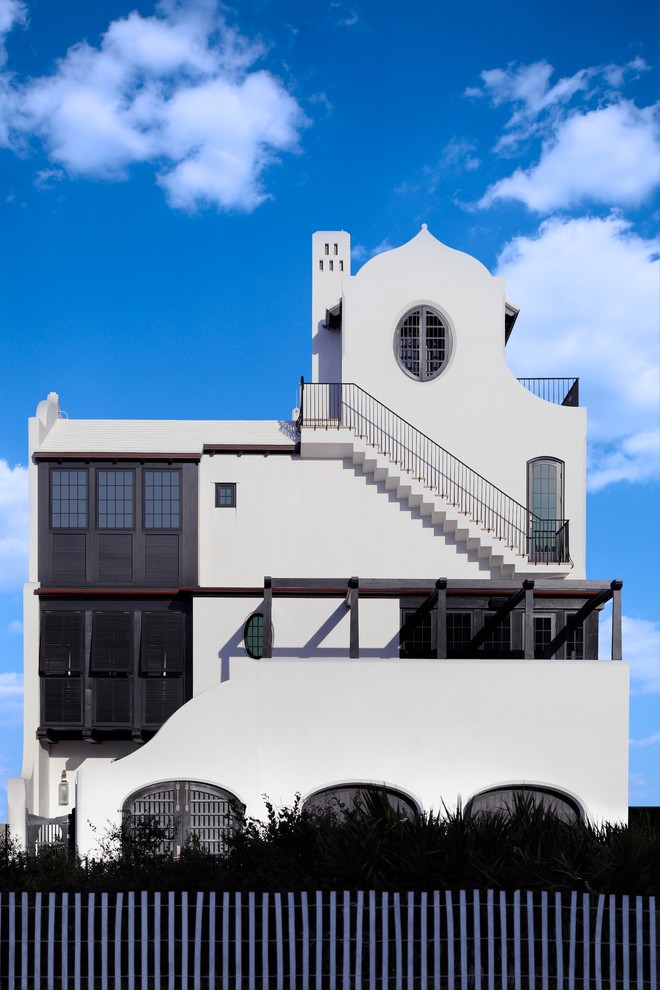 Пример оригинального дизайна: трехэтажный, белый дом в средиземноморском стиле с облицовкой из цементной штукатурки