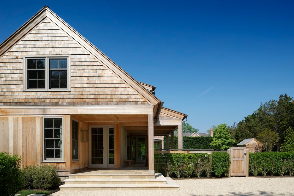 Large nautical two floor house exterior in New York with wood cladding and a pitched roof.