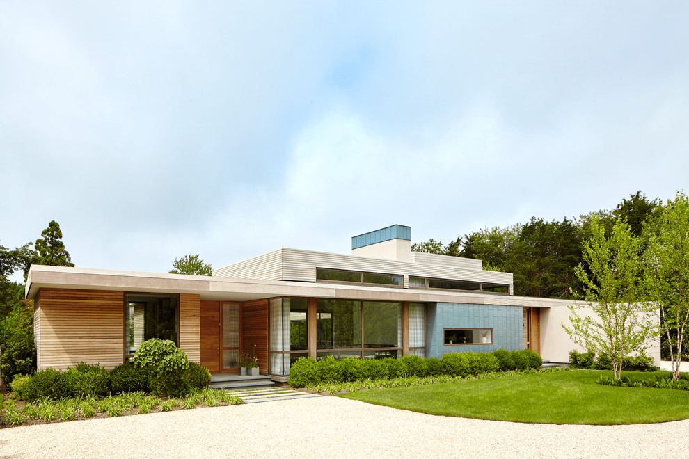 На фото: одноэтажный, разноцветный частный загородный дом в морском стиле с комбинированной облицовкой и плоской крышей с