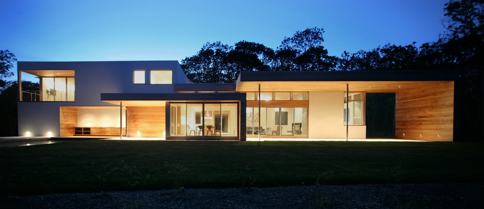 Immagine della villa grande beige moderna a due piani con rivestimento in legno e tetto piano