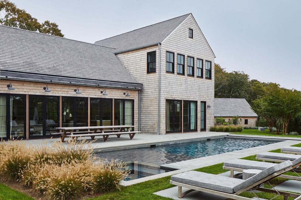 Zweistöckiges Maritimes Haus mit beiger Fassadenfarbe, Satteldach und Schindeldach in New York
