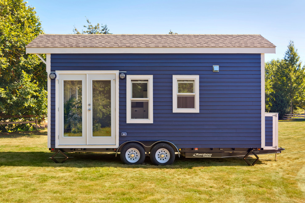 На фото: маленький, одноэтажный, деревянный, синий дом в морском стиле с двускатной крышей для на участке и в саду с