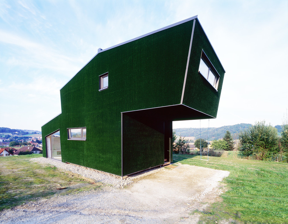 На фото: маленький, двухэтажный, деревянный, зеленый дом в современном стиле для на участке и в саду с