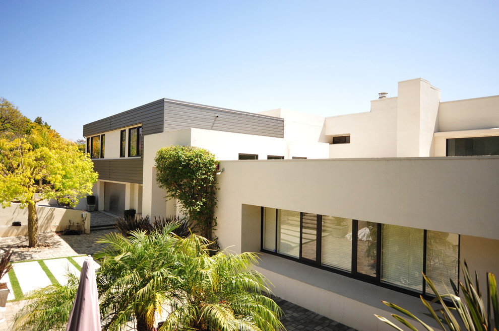 Inspiration pour une grande façade de maison multicolore minimaliste à un étage avec un revêtement mixte et un toit plat.