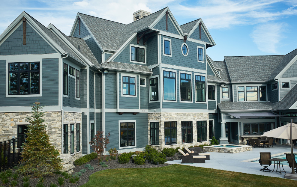 Идея дизайна: огромный, трехэтажный, синий частный загородный дом в классическом стиле с облицовкой из ЦСП, двускатной крышей и металлической крышей
