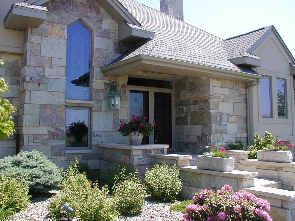 Mittelgroßes, Einstöckiges Shabby-Style Einfamilienhaus mit Steinfassade, bunter Fassadenfarbe und Schindeldach in Sonstige
