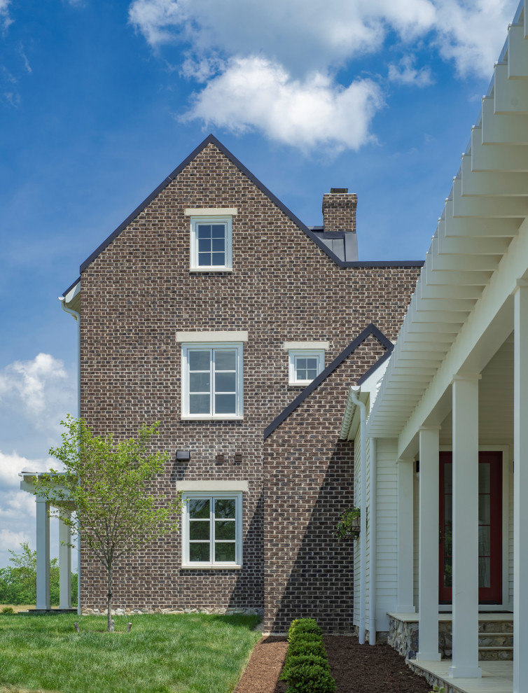 Стильный дизайн: трехэтажный, кирпичный частный загородный дом в классическом стиле с двускатной крышей и металлической крышей - последний тренд
