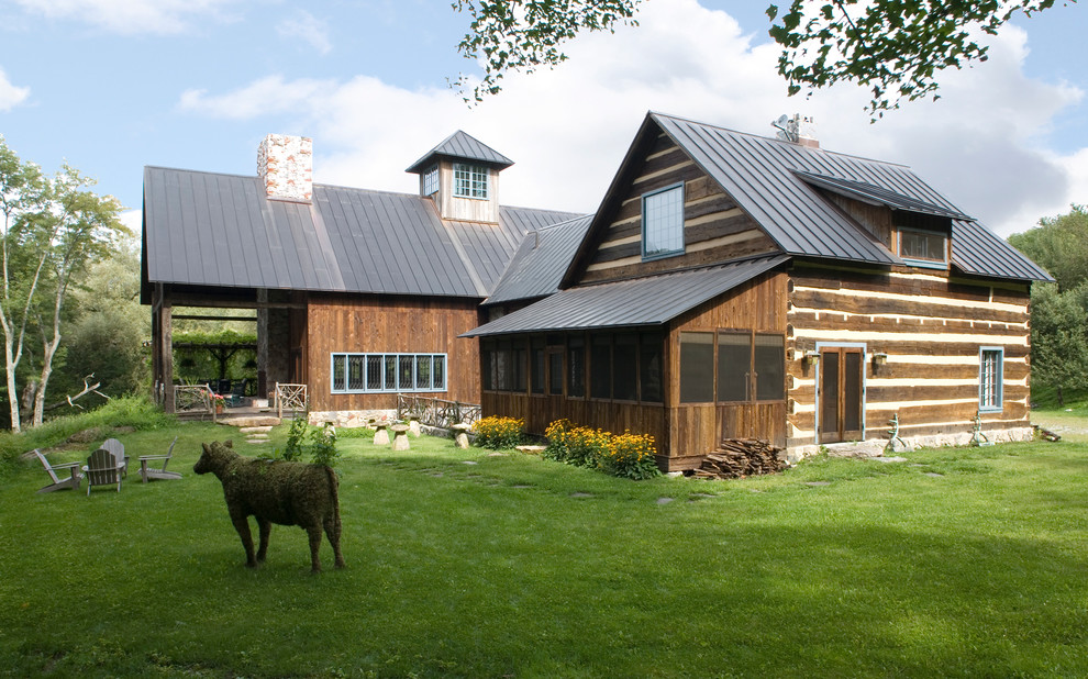 Foto della facciata di una casa country a due piani con rivestimento in legno e tetto a capanna