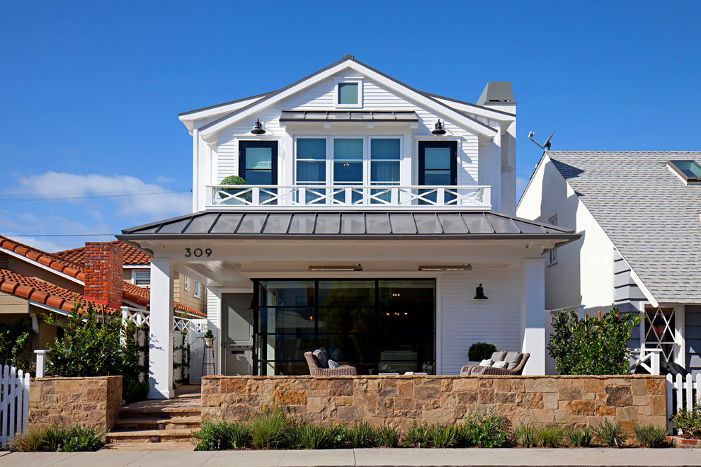Imagen de fachada blanca clásica renovada de tamaño medio de dos plantas con revestimiento de vinilo y tejado a dos aguas