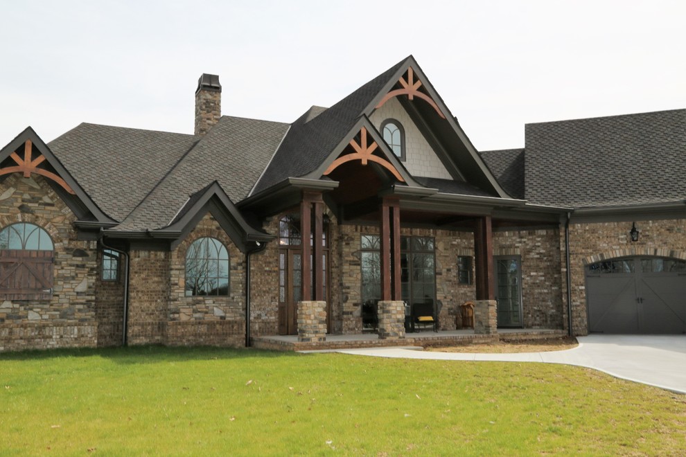 На фото: большой, двухэтажный, кирпичный, коричневый дом в стиле кантри с двускатной крышей с