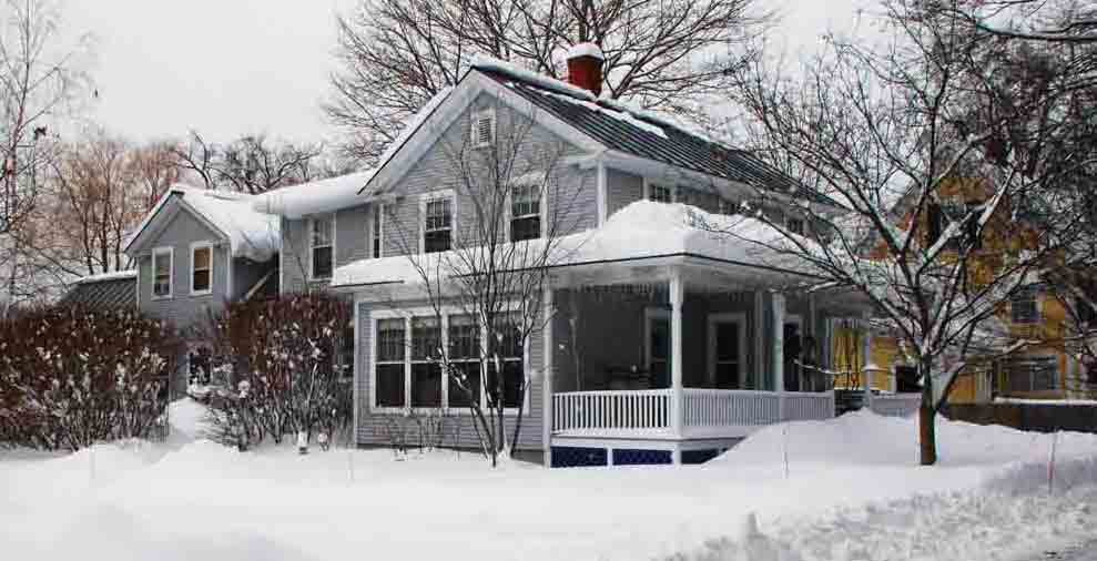 Ejemplo de fachada de casa gris campestre con revestimiento de madera, tejado a dos aguas y tejado de metal