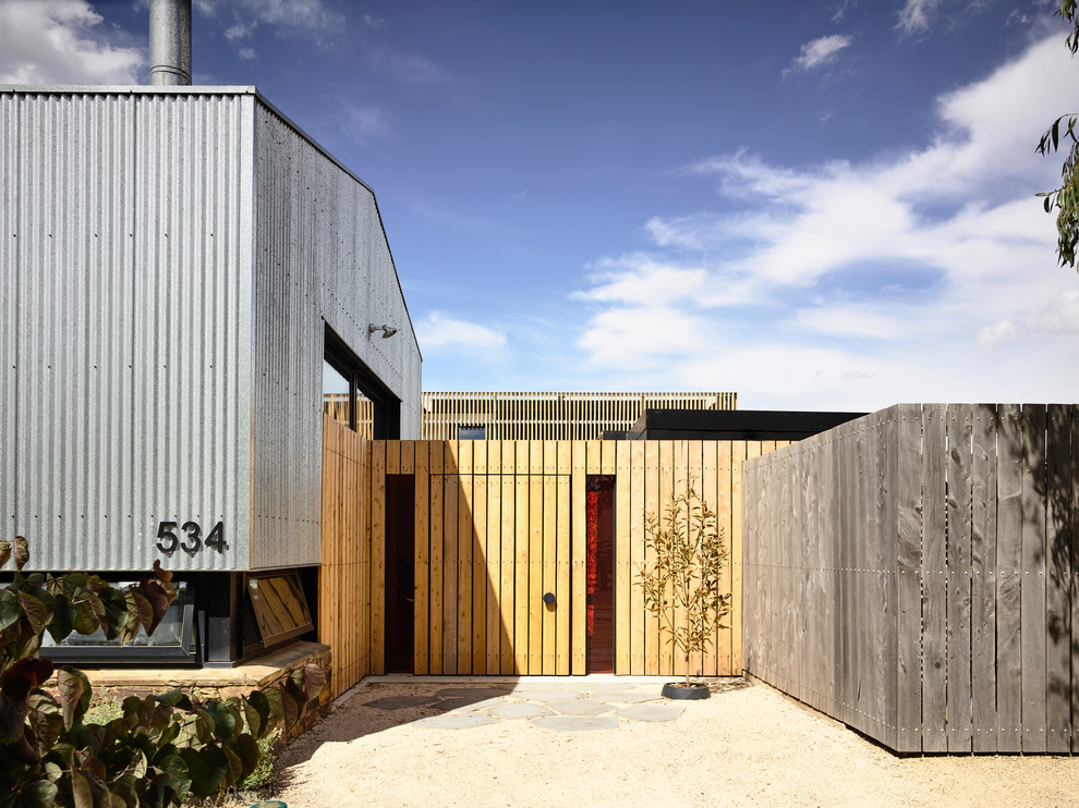 Gey contemporary detached house in Melbourne with mixed cladding and a pitched roof.