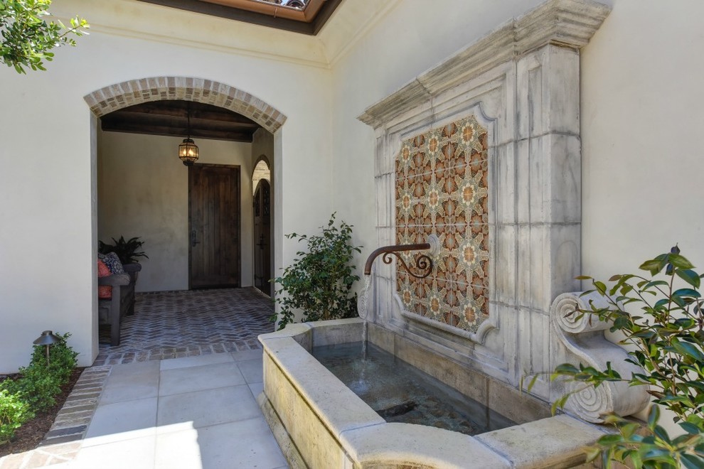 Diseño de fachada de casa beige mediterránea extra grande de dos plantas con revestimiento de estuco, tejado de un solo tendido y tejado de teja de barro