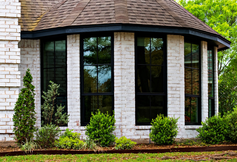 Imagen de fachada de casa blanca clásica renovada grande de dos plantas con revestimiento de ladrillo y tejado de teja de madera