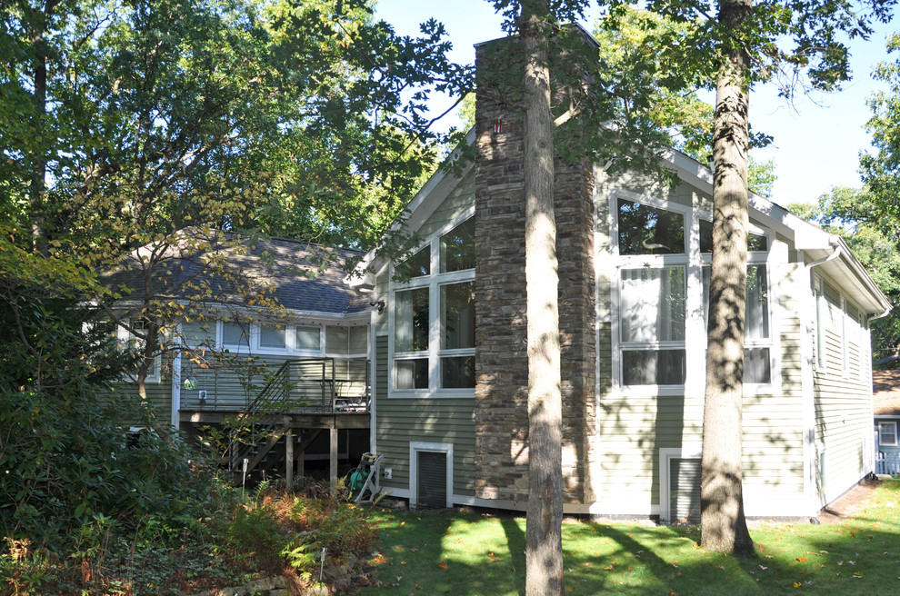 Foto della facciata di una casa verde classica a due piani di medie dimensioni con rivestimento in legno e tetto a padiglione