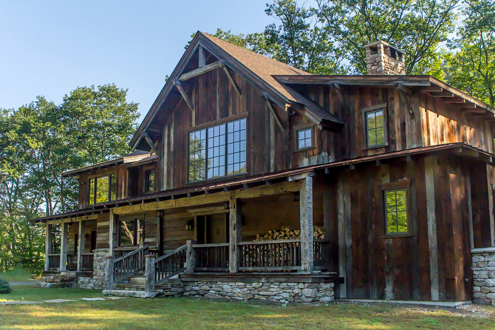 Mountain style brown two-story wood exterior home photo in Other with a mixed material roof