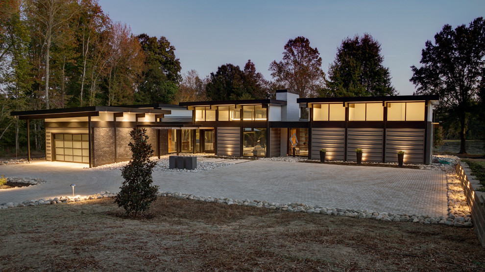 Foto de fachada de casa gris moderna grande de una planta con tejado plano y revestimientos combinados