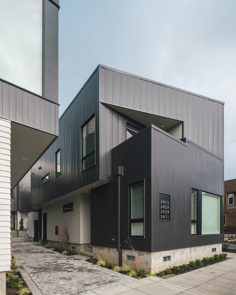 На фото: двухэтажный, серый дуплекс в стиле модернизм с облицовкой из металла с