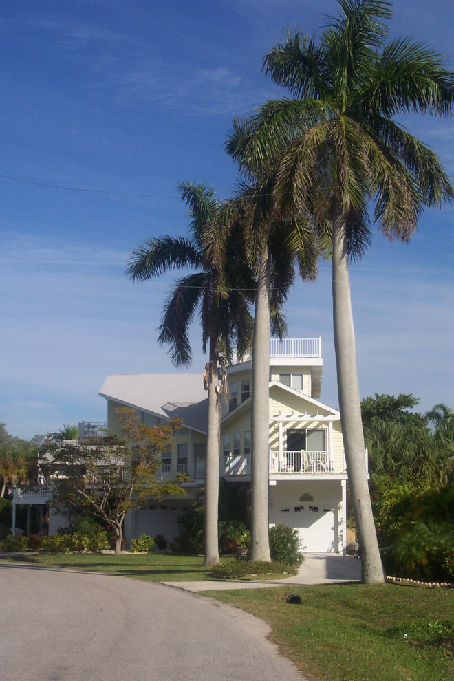 Mittelgroßes, Dreistöckiges Haus mit Vinylfassade und gelber Fassadenfarbe in Tampa