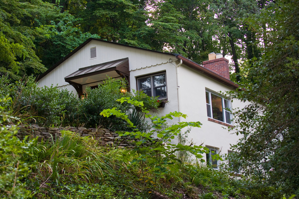 Réalisation d'une petite façade de maison blanche tradition en stuc de plain-pied avec un toit à deux pans.