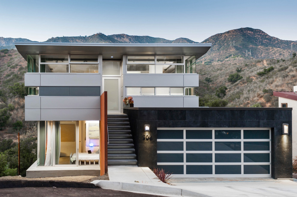 Свежая идея для дизайна: трехэтажный, серый дом среднего размера в современном стиле с облицовкой из металла и односкатной крышей - отличное фото интерьера