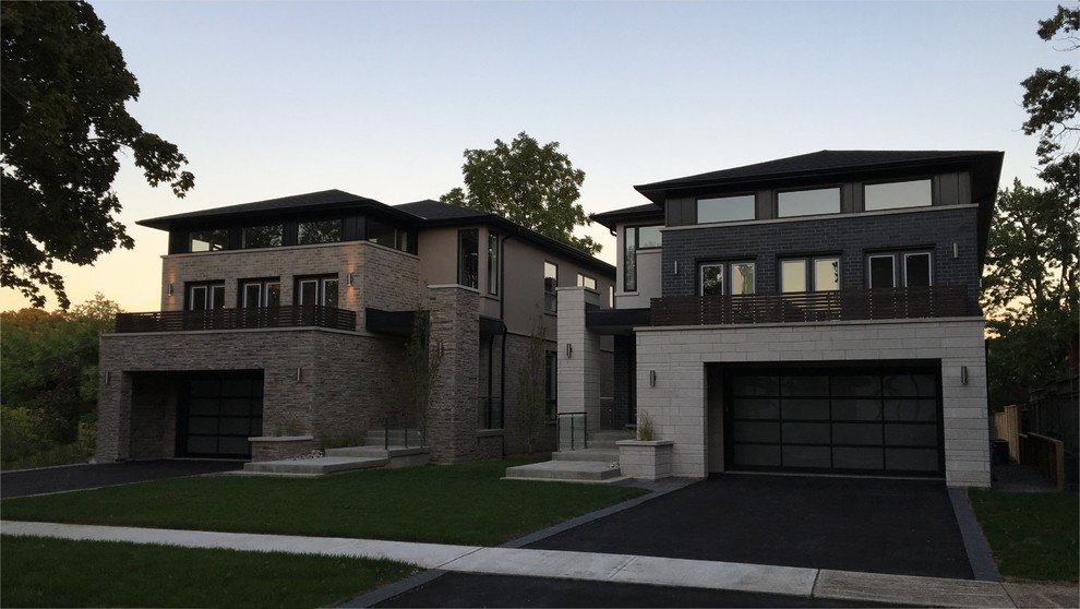This is an example of a medium sized and gey contemporary two floor concrete house exterior in Toronto with a hip roof.
