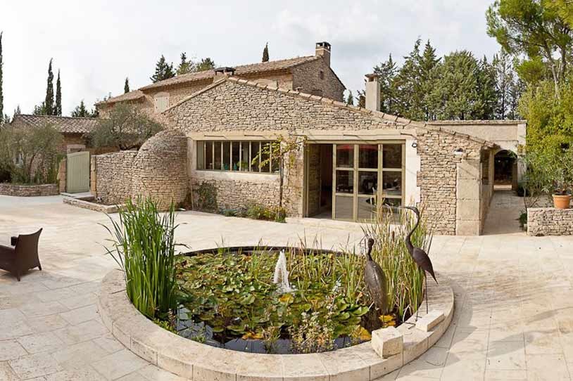 Ejemplo de fachada beige mediterránea grande de una planta con revestimiento de piedra y tejado a dos aguas