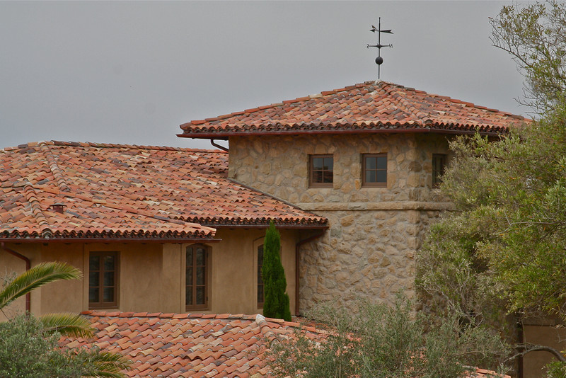 Foto della facciata di una casa grande beige rustica a due piani con rivestimento in pietra e tetto a padiglione