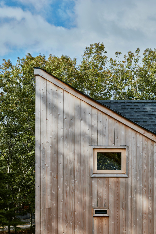На фото: маленький, двухэтажный, деревянный частный загородный дом в стиле ретро с черной крышей для на участке и в саду с