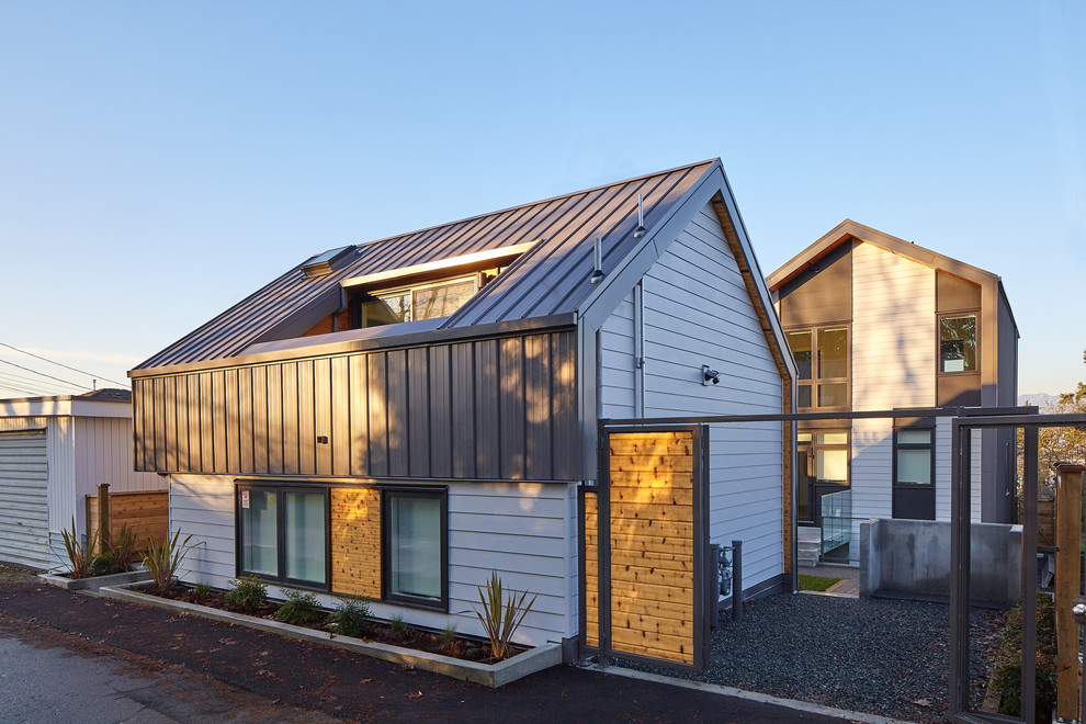 Kleines, Zweistöckiges Modernes Reihenhaus mit Metallfassade, weißer Fassadenfarbe, Satteldach und Blechdach in Vancouver