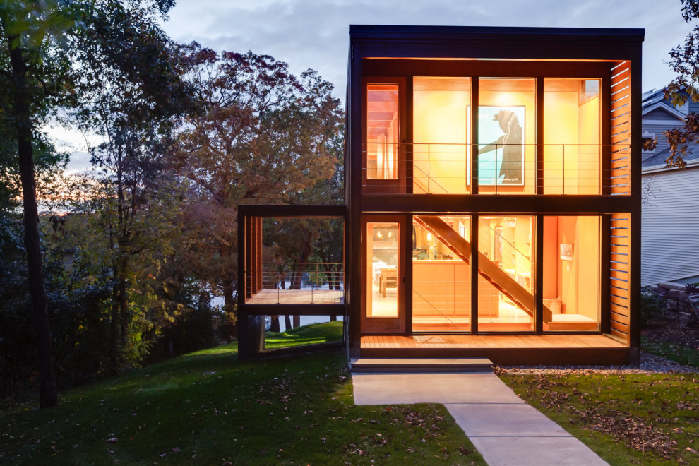 Réalisation d'une petite façade de maison marron minimaliste en bois à deux étages et plus avec un toit plat et un toit en métal.