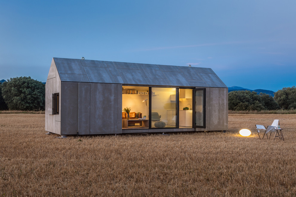 Small contemporary gray one-story concrete gable roof idea in Madrid