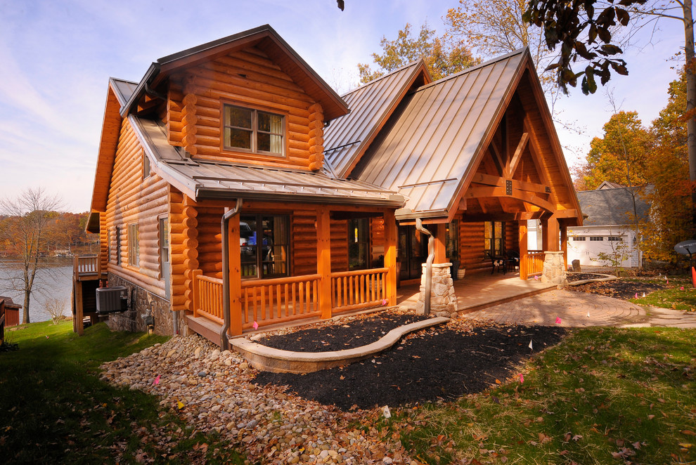 Diseño de fachada de casa marrón actual grande de dos plantas con revestimiento de madera y tejado de metal