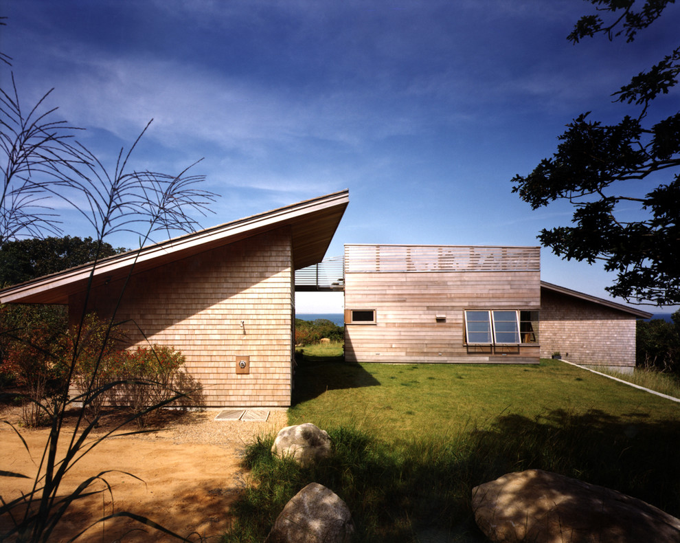Photo of a contemporary house exterior in Boston with wood cladding and a lean-to roof.