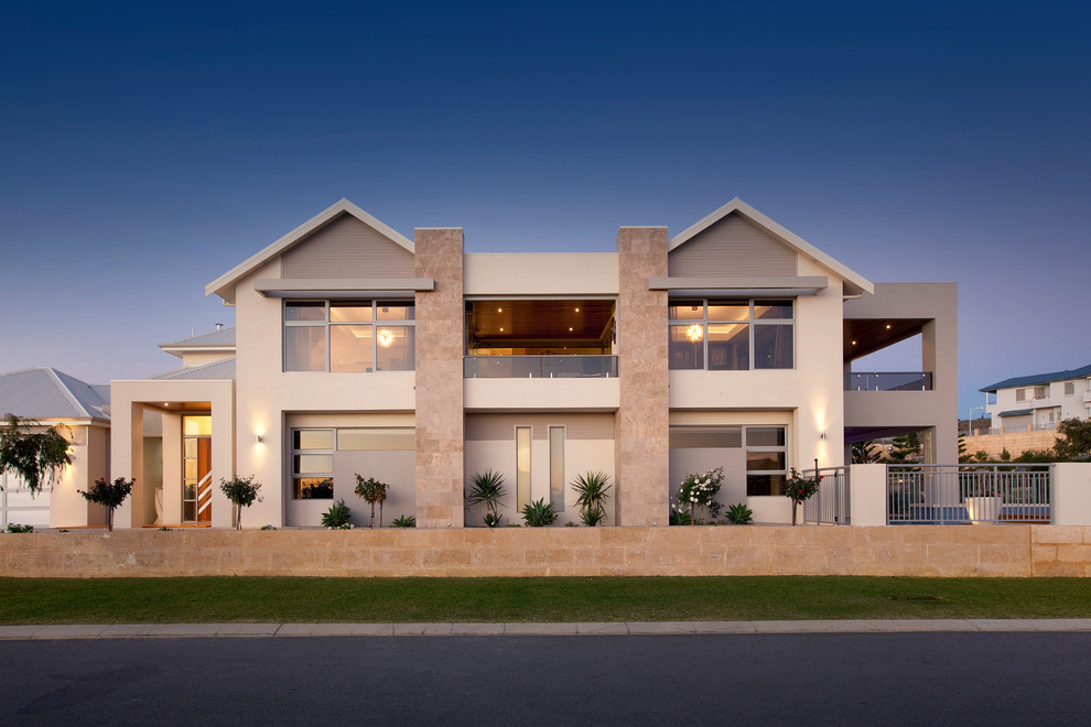 Стильный дизайн: двухэтажный, бежевый дом в современном стиле с облицовкой из цементной штукатурки и двускатной крышей - последний тренд