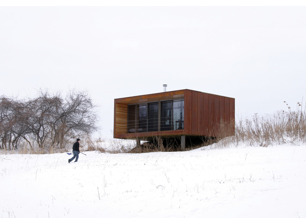 На фото: маленький, одноэтажный, коричневый дом в стиле модернизм с облицовкой из металла для на участке и в саду с