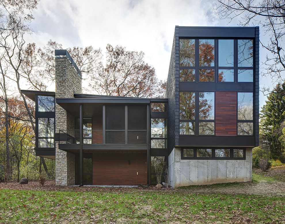 Inspiration pour une façade de maison noire minimaliste en verre avec un toit plat.