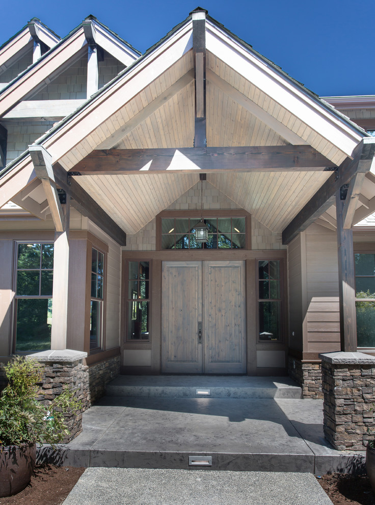 На фото: огромный, двухэтажный, коричневый дом в стиле кантри с комбинированной облицовкой и вальмовой крышей