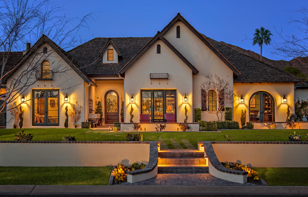 Huge french country beige one-story stucco exterior home idea in Phoenix with a hip roof