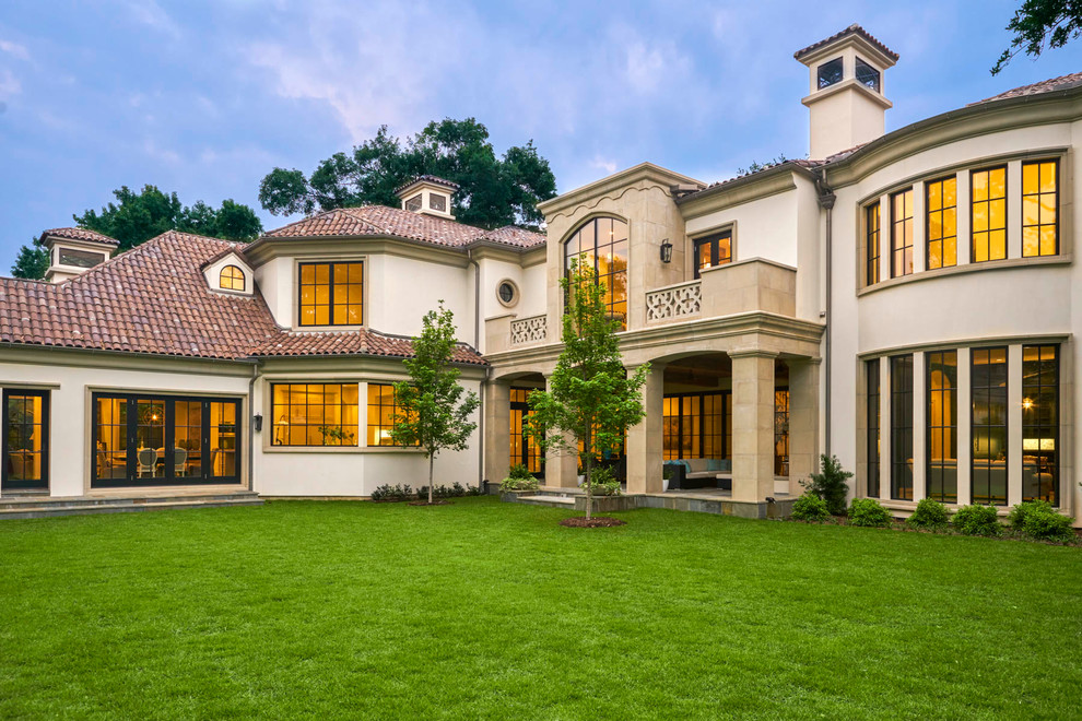 This is an example of a white mediterranean two floor house exterior in Dallas with a hip roof.