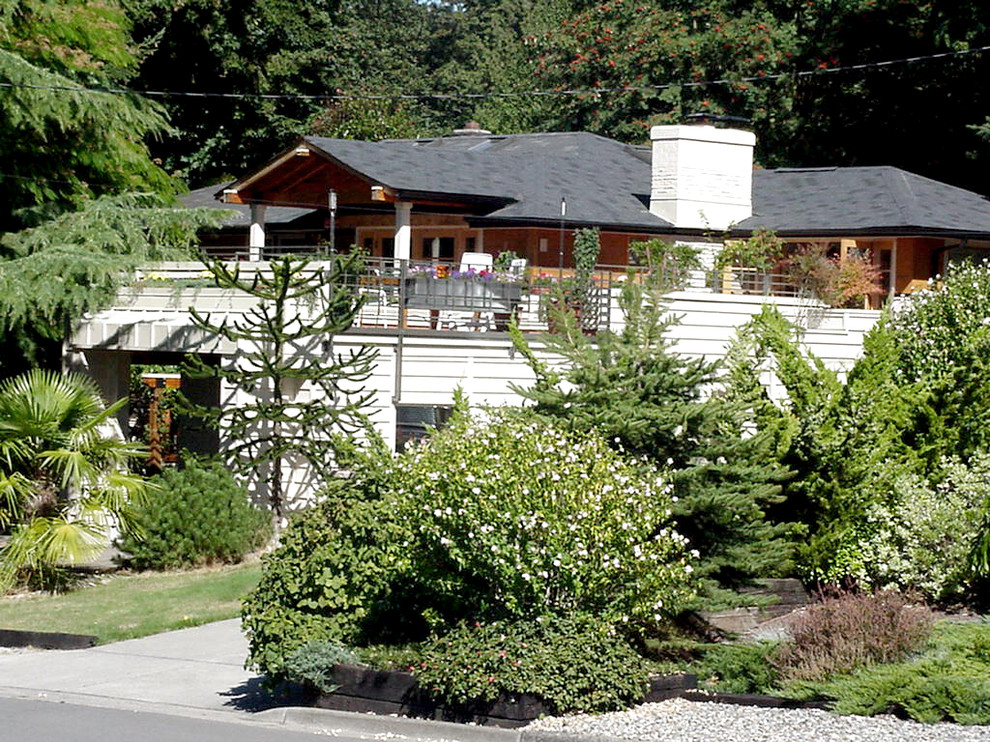 Diseño de fachada beige tradicional de tamaño medio de dos plantas con revestimiento de madera y tejado a dos aguas