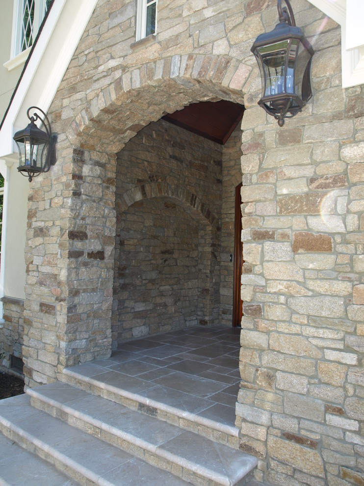 Réalisation d'une grande façade de maison marron design en pierre à un étage.