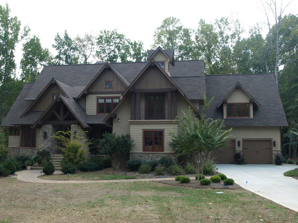На фото: большой, двухэтажный, коричневый дом в стиле кантри с облицовкой из камня