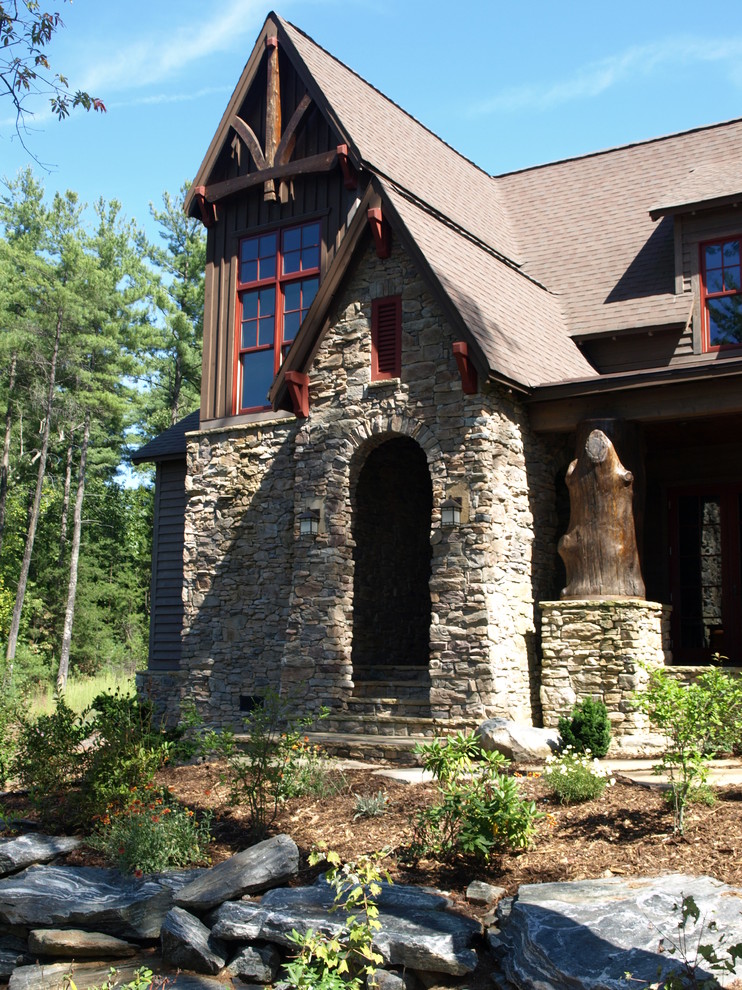 Large and brown rustic two floor house exterior in Charlotte with stone cladding.