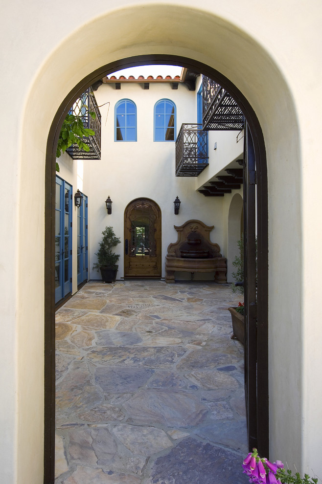 Ispirazione per la facciata di una casa beige mediterranea a due piani di medie dimensioni con rivestimento in stucco