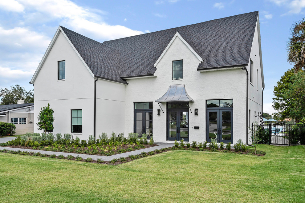 Example of a large transitional white two-story mixed siding house exterior design in Orlando with a hip roof and a shingle roof